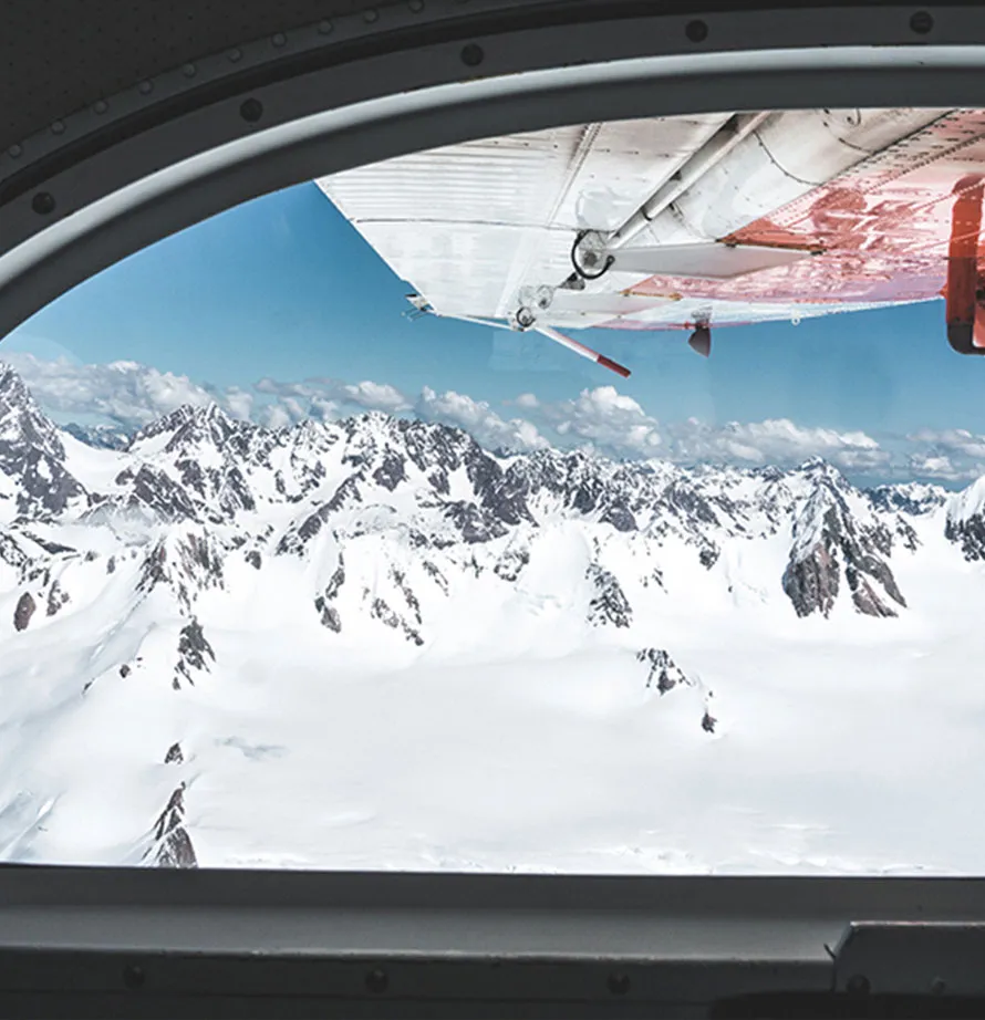 Inside a plane, looking out at a snowy mountain