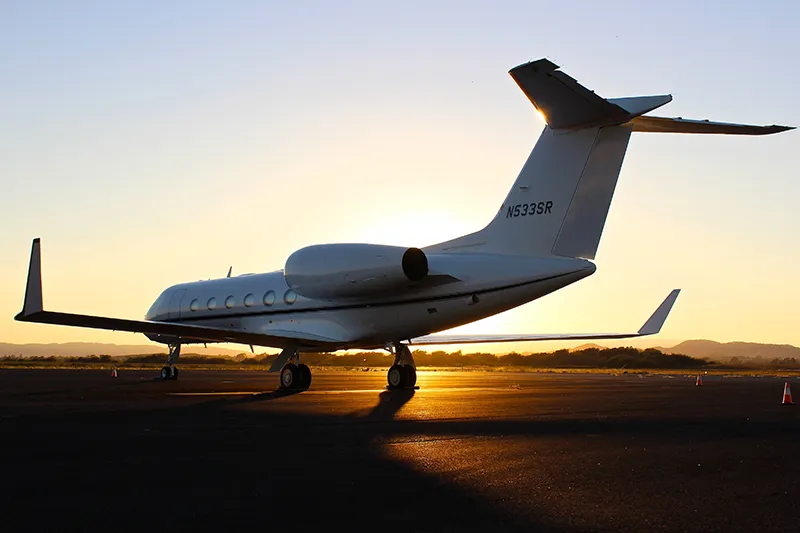 Business jet on runway during a sunset