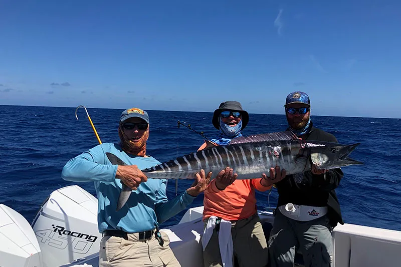 Three men holding up a large fish 