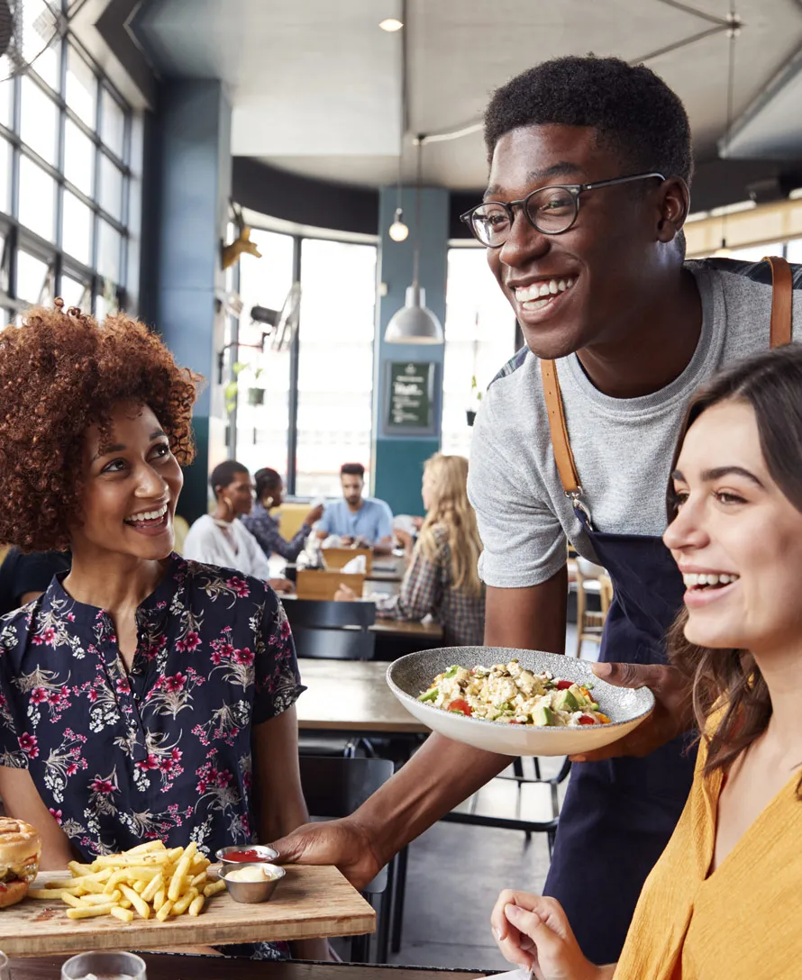 Restaurant Waiter serving food to two women