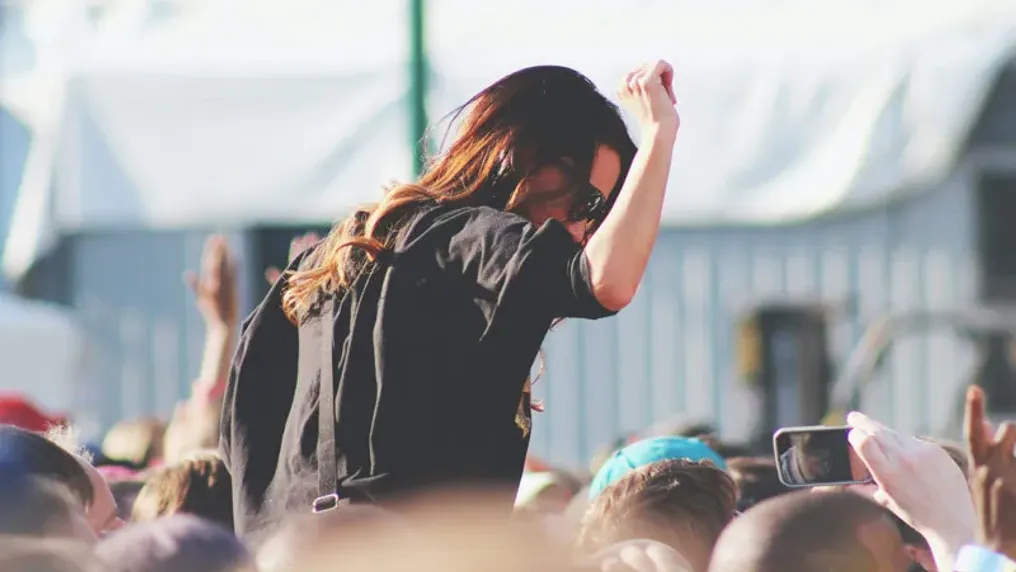 Person on shoulders in concert crowd